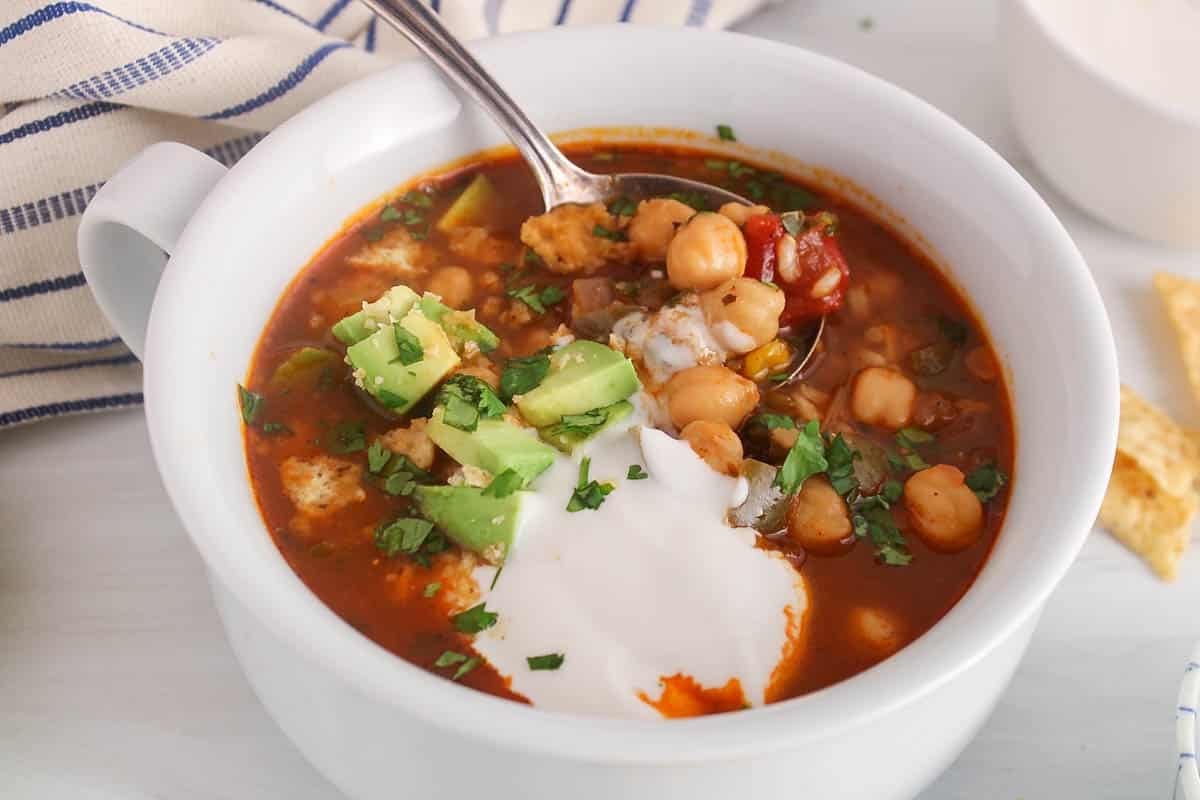 A spoon in a bowl of Mexican Chickpea soup.