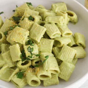 Bowl of creamy vegan zucchini pasta with fresh basil.