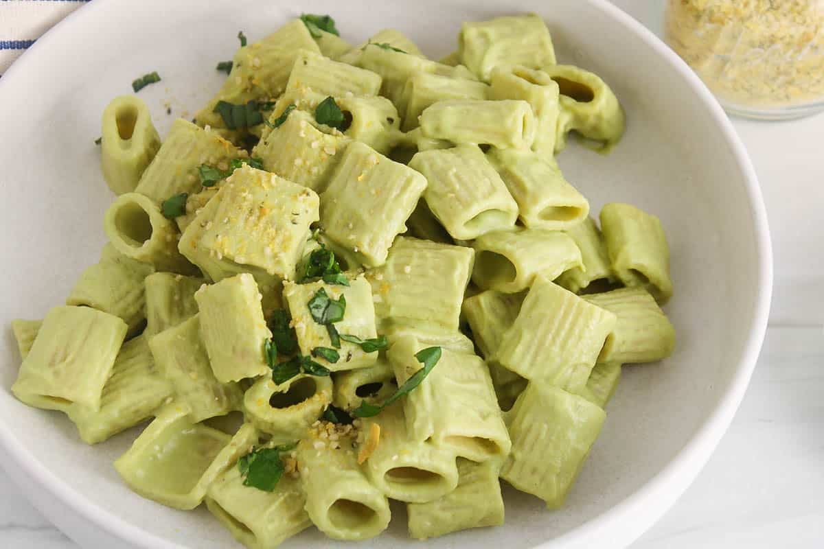 Bowl of creamy vegan zucchini pasta with fresh basil.