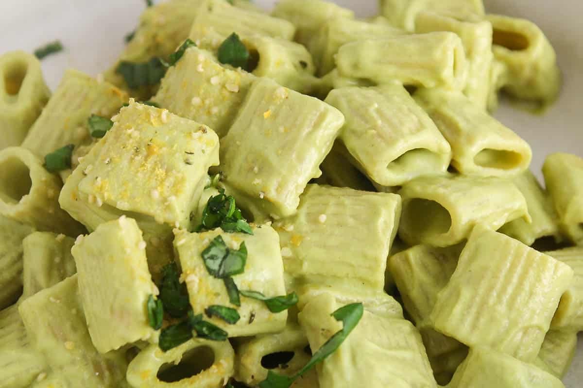 Bowl of creamy vegan zucchini pasta with fresh basil.