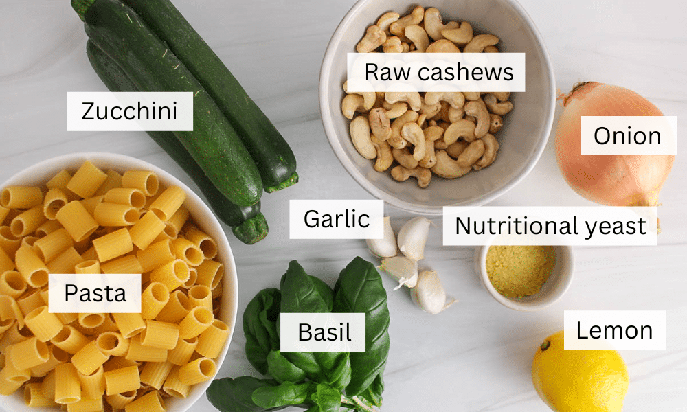 Ingredients to make a vegan zucchini pasta dish are placed on a table.