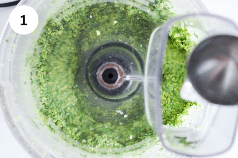 A food processor making pesto.